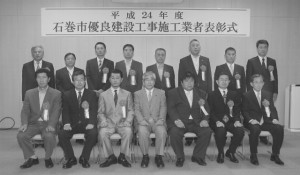 優良工事施工業者に選ばれ、亀山市長(前列中央)とともに記念写真に写る受賞企業の代表者たち