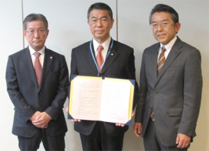 左から基本合意書を手にする渡部本部長、村井知事、張替理事長