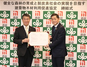 協定書を手に記念撮影する横井支店長(右)と村井知事